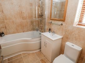 A bathroom with a bathtub, sink, and toilet at Oak Tree Cottage, Oldwalls, Llanrhidian, Gower