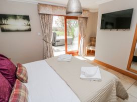 A bedroom with a bed and a television at Oak Tree Cottage in Oldwalls, Llanrhidian, Gower