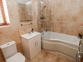 A bathroom with a bath tub, sink, and toilet at Oak Tree Cottage in Oldwalls, Llanrhidian, Gower