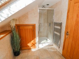 A bathroom with a shower and towel rail at Oak Tree Cottage, Oldwalls, Llanrhidian, Gower