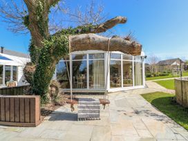 An outdoor area with a swing hanging from a tree at Oak Tree Cottage in Oldwalls, Llanrhidian, Gower