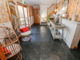 A hallway with a chair and table at Oak Tree Cottage, Oldwalls, Llanrhidian, Gower