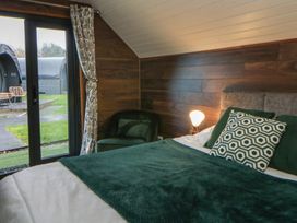 A bedroom with a bed and a chair at Garden lodge 3 Swansea