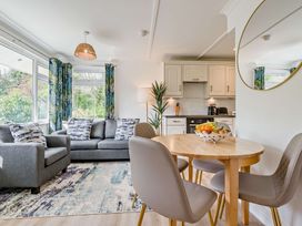 A living room with a sofa and dining table at Kernow Nook Spa, Perranporth