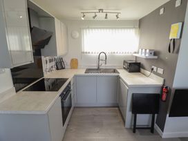 A kitchen with a sink and stove at No.49 Cherry Park in Chapel St Leonards
