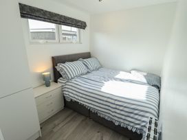 A bedroom with a bed and nightstand at No.49 Cherry Park in Chapel St Leonards