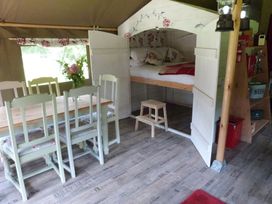 A dining area with a table and chairs beside a bed at Ceri in Newcastle Emlyn