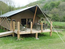 A tent with a deck and furniture outside at Ceri in Newcastle Emlyn