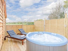 An outdoor area with a hot tub and loungers at Typhoon Lodge in Winchester