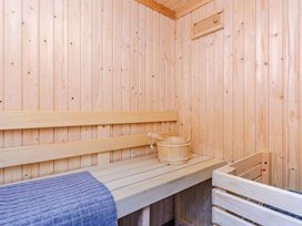 A sauna with wooden bench and bucket at Typhoon Lodge in Winchester