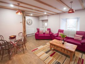 A living room with pink sofas and a wooden coffee table at Millers Cottage Newcastle Emlyn