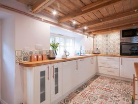 A kitchen with cabinets and appliances at Millers Cottage Newcastle Emlyn