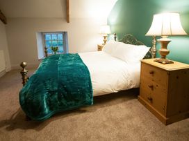 A bedroom with a bed and nightstands at Millers Cottage Newcastle Emlyn