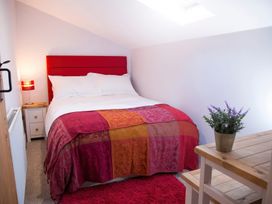 A bedroom with a bed and nightstand at Millers Cottage in Newcastle Emlyn