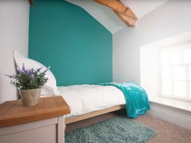 A bedroom with a bed and plant at Millers Cottage Newcastle Emlyn