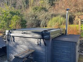 A hot tub with cover and chimney in the garden at Millers Cottage Newcastle Emlyn