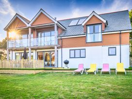A house with a balcony and sun loungers at Nan's House Spa in Marhamchurch
