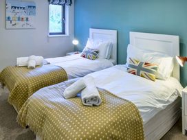 A bedroom with twin beds and a painting at Nan's House Spa in Marhamchurch