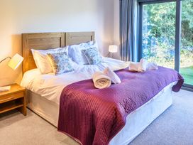 A bedroom with a bed and a sliding door at Nan's House Spa in Marhamchurch