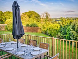 An outdoor dining area with a table and chairs at Nan's House Spa in Marhamchurch