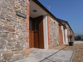 An exterior view of Barleypark with stone walls and a door in Marhamchurch