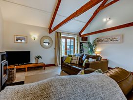 A living room with a sofa and television at Barley Park in Marhamchurch