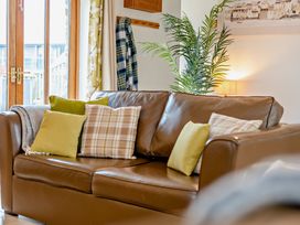 A living room with a sofa and cushions at Barley Park in Marhamchurch