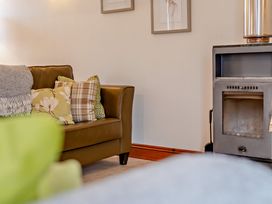 A living room with a couch and a stove at Barley Park in Marhamchurch