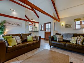 A living room with sofas and a door at Barley Park in Marhamchurch