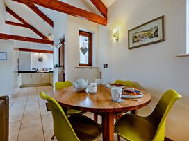A kitchen with a dining table and chairs at Barley Park Marhamchurch