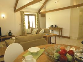 A living room with a sofa and dining area at Barley Park in Marhamchurch