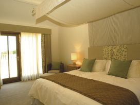 A bedroom with a bed and window at Barley Park in Marhamchurch