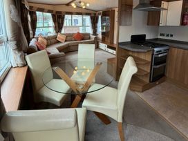 A living room with a dining table and sofa at Wyreside Lakes - Holiday Accommodation 17442 Lancaster