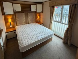A bedroom with a bed and lamp at Wyreside Lakes - Holiday Accommodation 17442 Lancaster