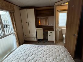 A bedroom with a bed, wardrobe, desk, and toilet at Wyreside Lakes - Holiday Accommodation 17442, Lancaster