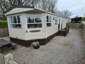 A mobile home with steps and a picnic table at Wyreside Lakes - Holiday Accommodation 17442, Lancaster