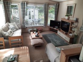 A living room with a sofa and television at Aberdunant Hall Holiday Park - Holiday Accommodation 21897, Porthmadog