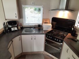 A kitchen with a sink and gas stove at Aberdunant Hall Holiday Park - Holiday Accommodation 21897 Porthmadog