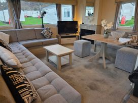 A living room with a sofa and coffee table at Brynowen Holiday Park - Holiday Accommodation 22432 Borth