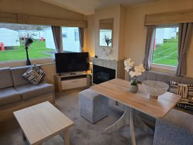 A living room with a sofa and television at Brynowen Holiday Park - Holiday Accommodation 22432 in Borth