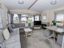 A living room with a sofa TV and dining table at Brynowen Holiday Park - Holiday Accommodation 22432 Borth