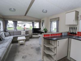 A living room with a sofa and television at Brynowen Holiday Park - Holiday Accommodation 22432 Borth