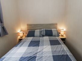 A bedroom with a bed and lamps at Brynowen Holiday Park - Holiday Accommodation 22432, Borth