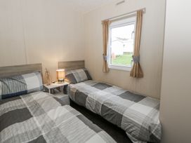 A bedroom with two beds and a window at Brynowen Holiday Park - Holiday Accommodation 22432, Borth
