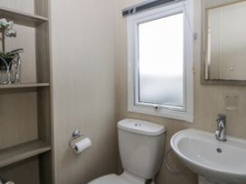 A bathroom with a toilet and sink at Brynowen Holiday Park - Holiday Accommodation 22432 Borth