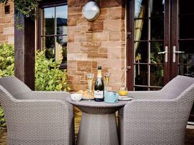 An outdoor seating area with a table and chairs at Ullswater Apartment in Penrith