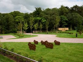 An outdoor area with sheep sculptures and trees at Ullswater Apartment in Penrith
