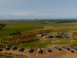 A landscape with huts and fields near the sea at The Weir North Berwick