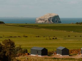 A view of housing units with a rock formation in the background at The Weir in North Berwick