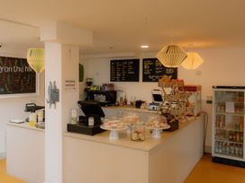 A cafe counter with a menu board and display case at The Weir in North Berwick
